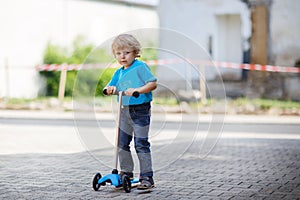 Little toddler boy riding on his bycicle in summer