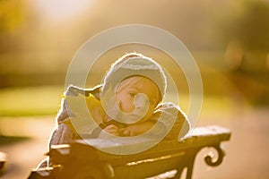 Little toddler child, boy, playing with airplane and knitted teddy bear in autumn park