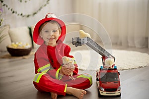 Little toddler child, playing with fire truck car toy and little chicks at home