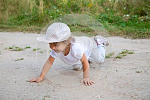 little toddler crawling in sand in counrtyside