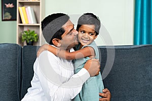 little toddler daughter hugging father by kissing at home - concept of love, parenthood and harmony