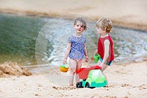 Little toddler friends having fun together on the beach
