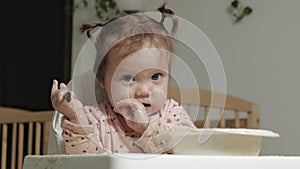 Little toddler girl eating porridge.