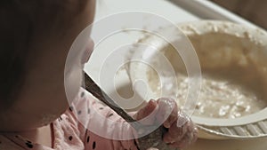 Little toddler girl eating porridge.