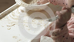 Little toddler girl eating porridge.