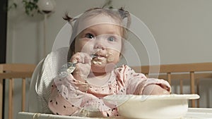 Little toddler girl eating porridge.