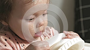 Little toddler girl eating porridge.