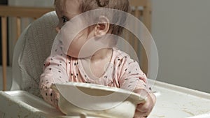 Little toddler girl eating porridge.