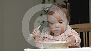 Little toddler girl eating porridge.