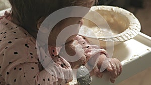 Little toddler girl eating porridge.