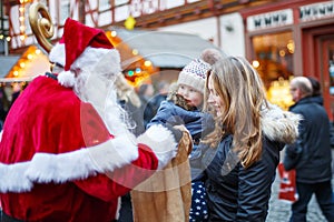 Little toddler girl with mother on Christmas market.