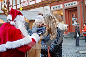 Little toddler girl with mother on Christmas market.