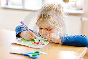 Little toddler girl painting animals and using scissors. Concept of activity of children during pandemic corona virus