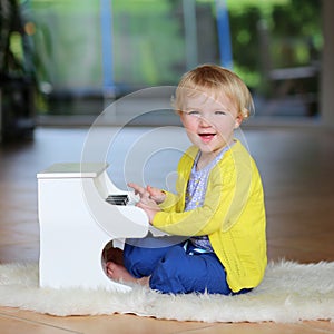 Little toddler girl plays toy piano