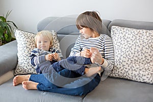 Little toddler and his older brother, having fun at home, tickling and giggle