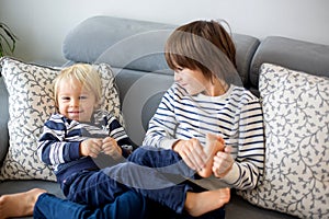 Little toddler and his older brother, having fun at home, tickling and giggle photo