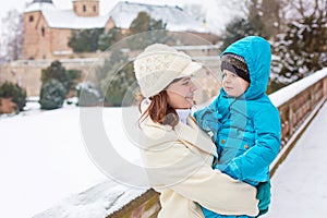 Little toddler kid boy and mother having fun with snow on winter day