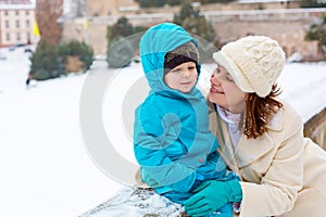 Little toddler kid boy and mother having fun with snow on winter day