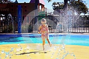 Little Toddler Kid Playing Outside in Water at Splash Park