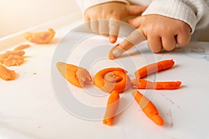 Little toddler plays play dough. Modeling orange sun. Creativity imagination