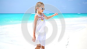 Little tourist girl walking at beach during caribbean vacation