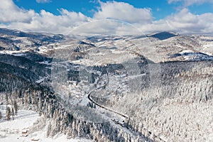 Little town in the Carpathian mountains at winter time. Majestic aerial landscape