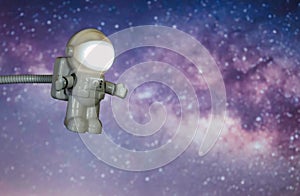 Little toy astronaut traveling through space, with a background of the Milky Way and the Galactic Center.