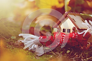 Little toy house wrapped scarf in autumn forest