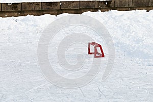 Little training red hockey goal on ice rink in the park. Active winter outdoor games