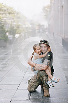 Little Ukrainian girl meets her father from the war during his vacation and joyful embraces him