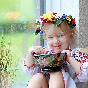 Little ukrainian girl in national dress with traditional food