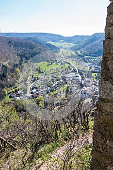 Little village in the middle of the german countryside with hills, forests, fields and meadows and the walls of a castle