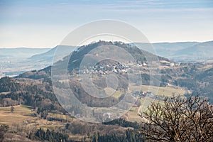 Little village in the middle of the german countryside with hills, forests, fields and meadows and the walls of a castle