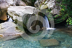 Little waterfall among the rocks in mountain forest