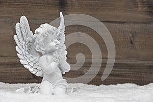 Little white angel ion wooden background