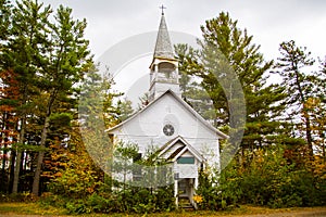 A little white country church in the beginnings of fall colors