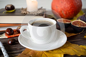 Little white cup of coffee on the table in autumn style