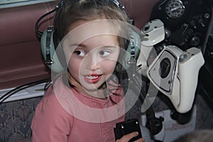 Little white girl sitting in airplane with headphones