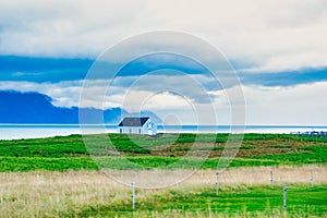 A little a little white house in a field on the prairie, clouds in the b house in a field on the prairie, clouds in the background