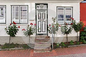 Little white house with red roses in Schleswig