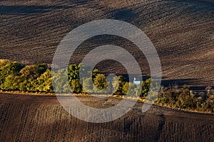 Little white wedding chapel hidden behind the trees in the autumn, amid the plowed fields.Kyjov South Moravia.Czech Republic.