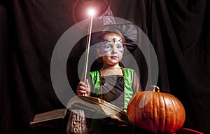 Little witch reads the Book of Spells