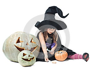 Little witch sits near tykov and considers candies