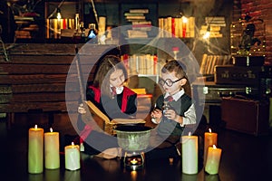 Little wizards read magic book and brew a potion . Halloween party. Cosplay Harry Potter