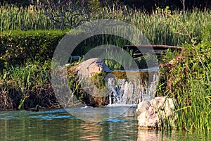 Little wooden bridge and waterfall in a garden