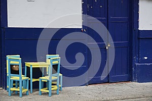 Little wooden chairs and table in front of a blue house, blue facade in Jardin, Eje Cafetero, Colombia photo