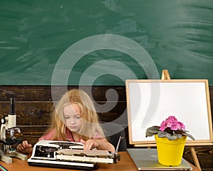 Little writer work on book at desk. Girl writer type on typewriter