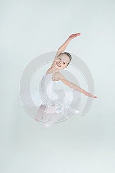 Little young ballerina poses on camera