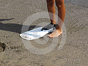 Little Young Boy Legs On Sand Beach in one Swimfin Flippers During Summer Vacation
