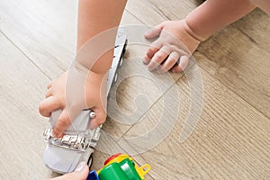 Little young caucasian boy plays with colorful toy cars indoors.